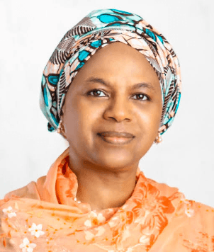Professional profile of Dr Fatimah Kyari, wearing a modest orange top paired with a coloured print scarf wrapper around her head.